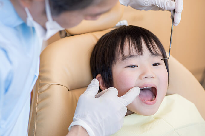 歯医者で治療を受ける子供